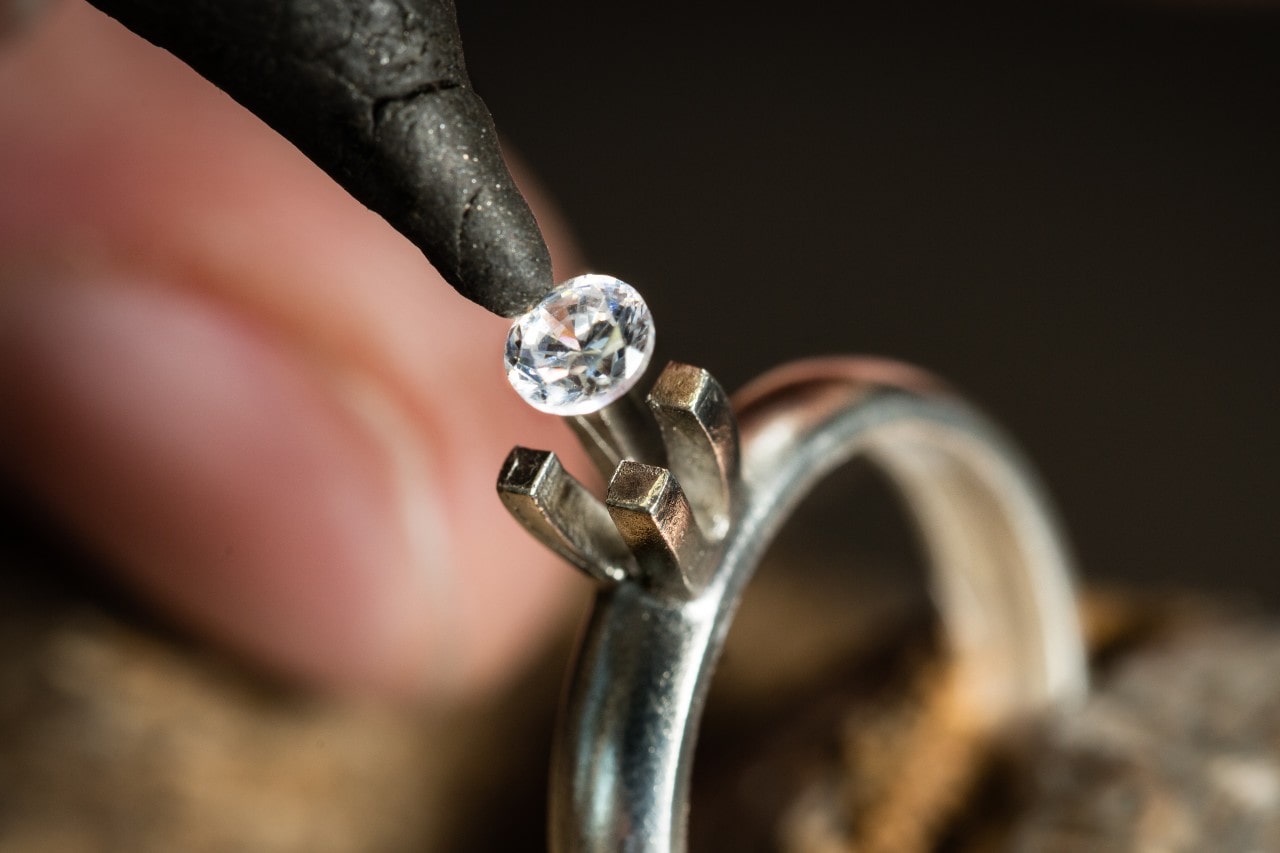 Goldsmith mounts a diamond into a solitaire engagement ring