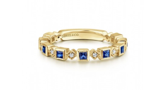 a yellow gold stackable fashion ring set with diamonds and blue sapphires