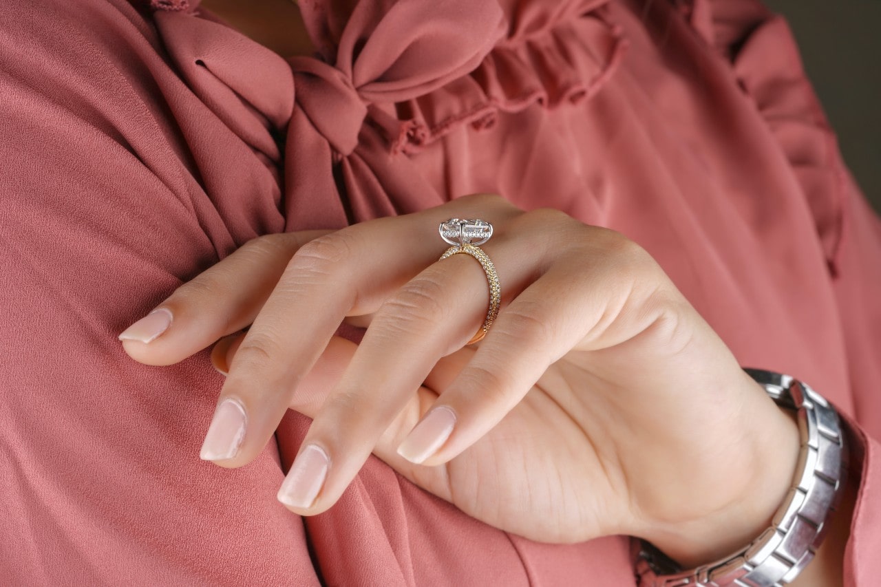 A woman wearing a micro-pave side stone engagement ring.