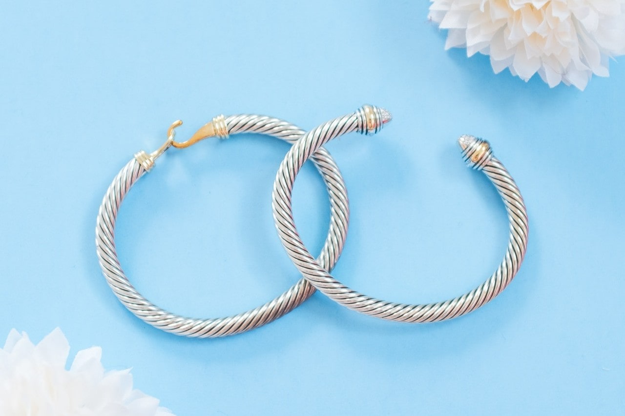 A close-up of a matching pair of bracelets on a sky blue backdrop.